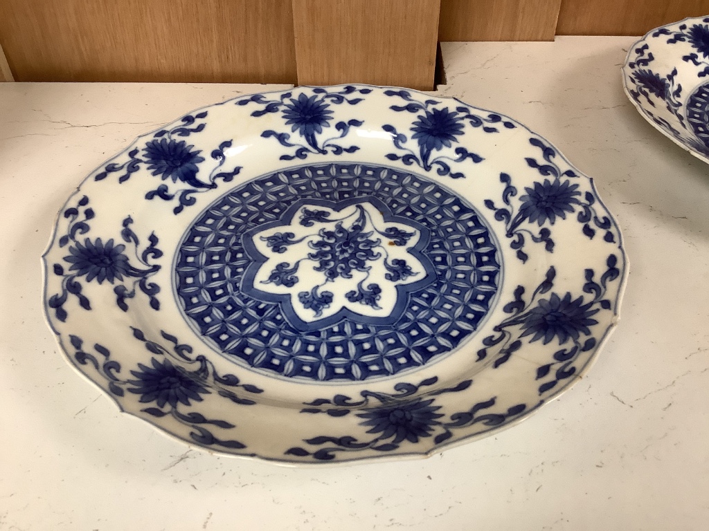 A pair of Chinese blue and white porcelain plates, Kangxi mark and period, with shaped borders and floral motifs, diameter 20cm